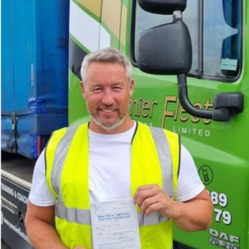 Man holding pass cerificate for HGV Driver Training Category C+E with PFS Training