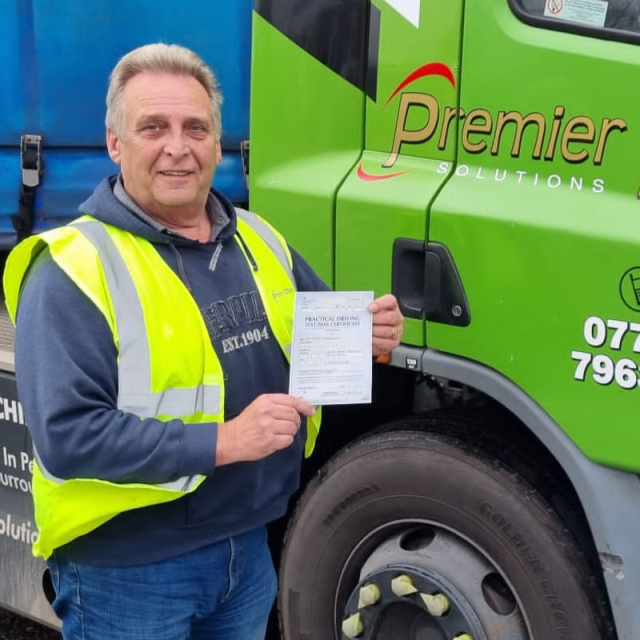 Man holding pass cerificate for HGV Driver Training Category C+E with PFS Training