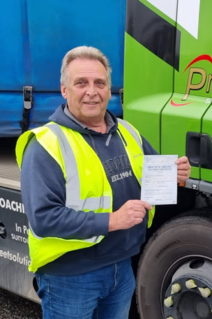 Man holding pass cerificate for HGV Driver Training Category C+E with PFS Training