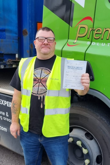 Man holding pass cerificate for HGV Driver Training Category C+E with PFS Training