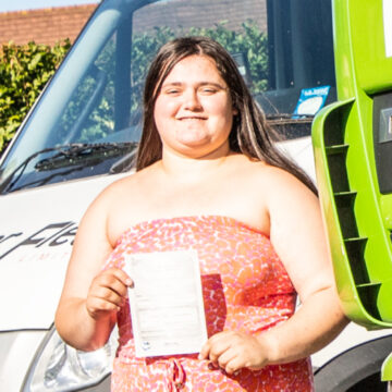 Woman holding pass cerificate for HGV Driver Training Category C+E with PFS Training