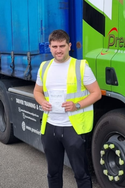 Man holding pass cerificate for HGV Driver Training Category C+E with PFS Training